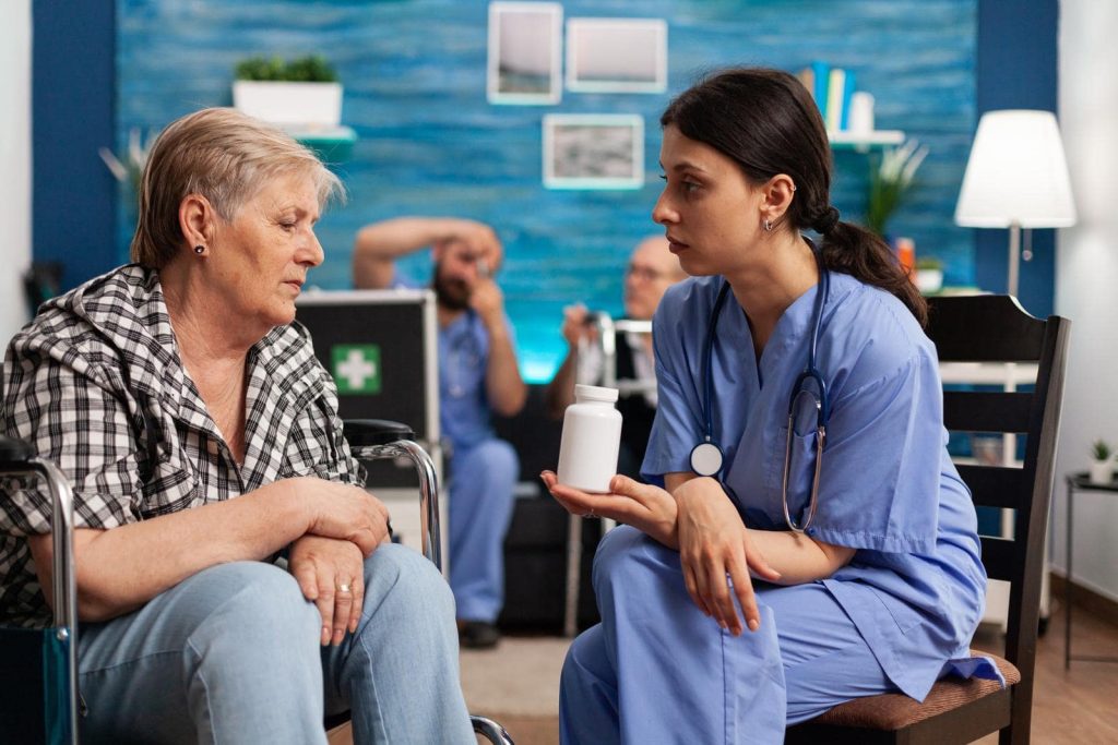 Social prescribing link worker helping elderly woman with her medication