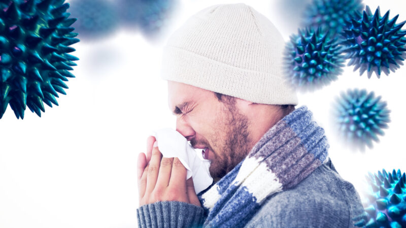 composite-image-of-handsome-man-in-winter-fashion-blowing-his-nose